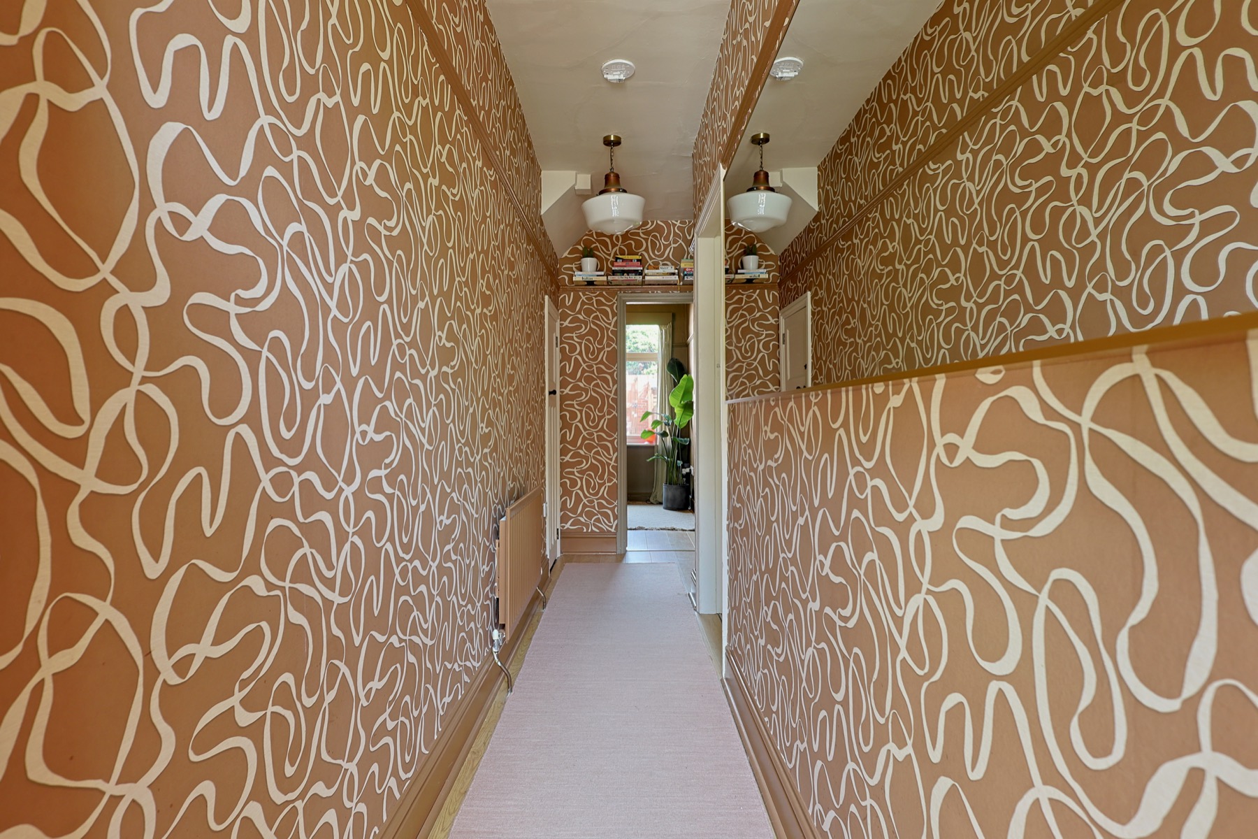 A long hallway with patterned wallpaper in a Heaton terrace, photographed by Bowson